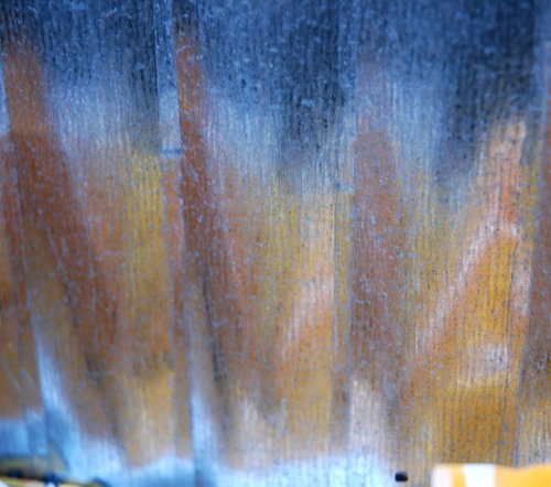 Reflections in a corrugated metal trash can